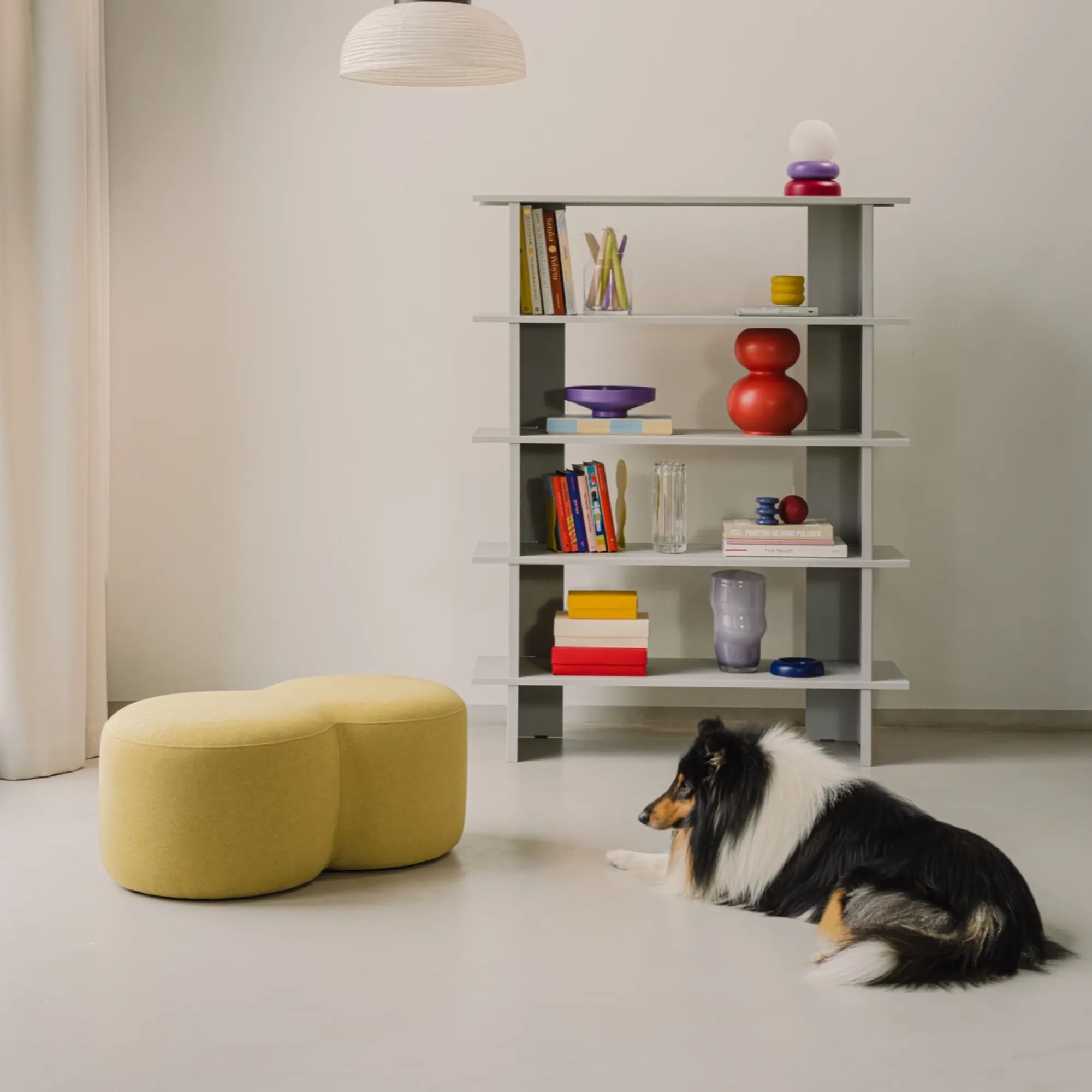 Umbo Pouf in cozy reading nook with knitted throw and books