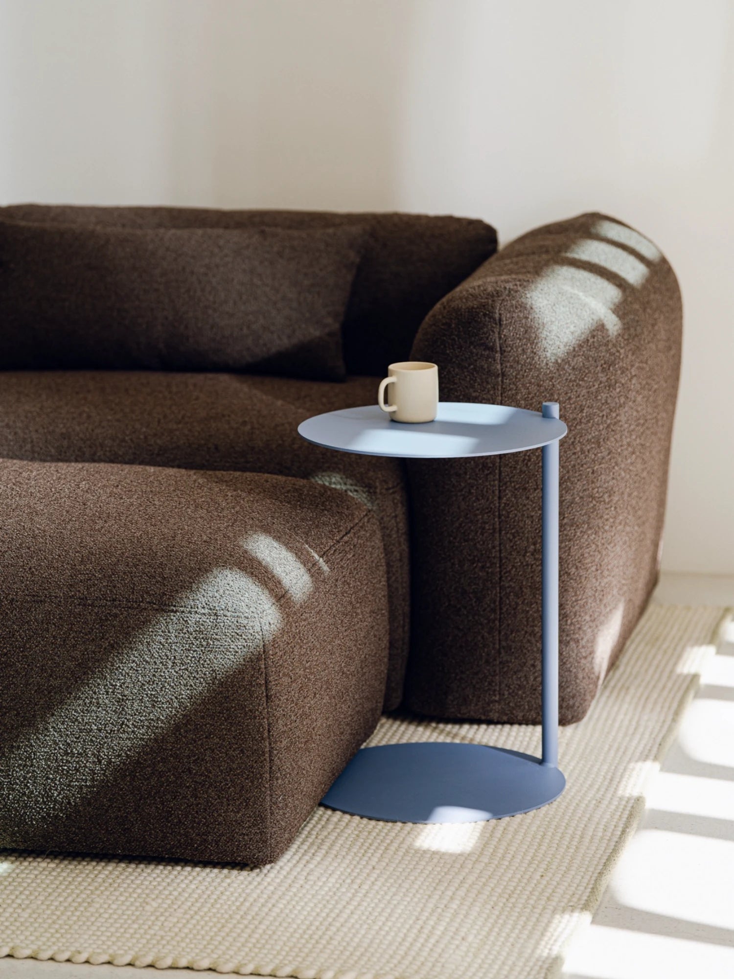 noo.ma Yaro Sofa, a contemporary modular sofa upholstered in a rich dark brown, textured bouclé-like fabric, featuring a plush, low-profile design and rounded organic silhouette.