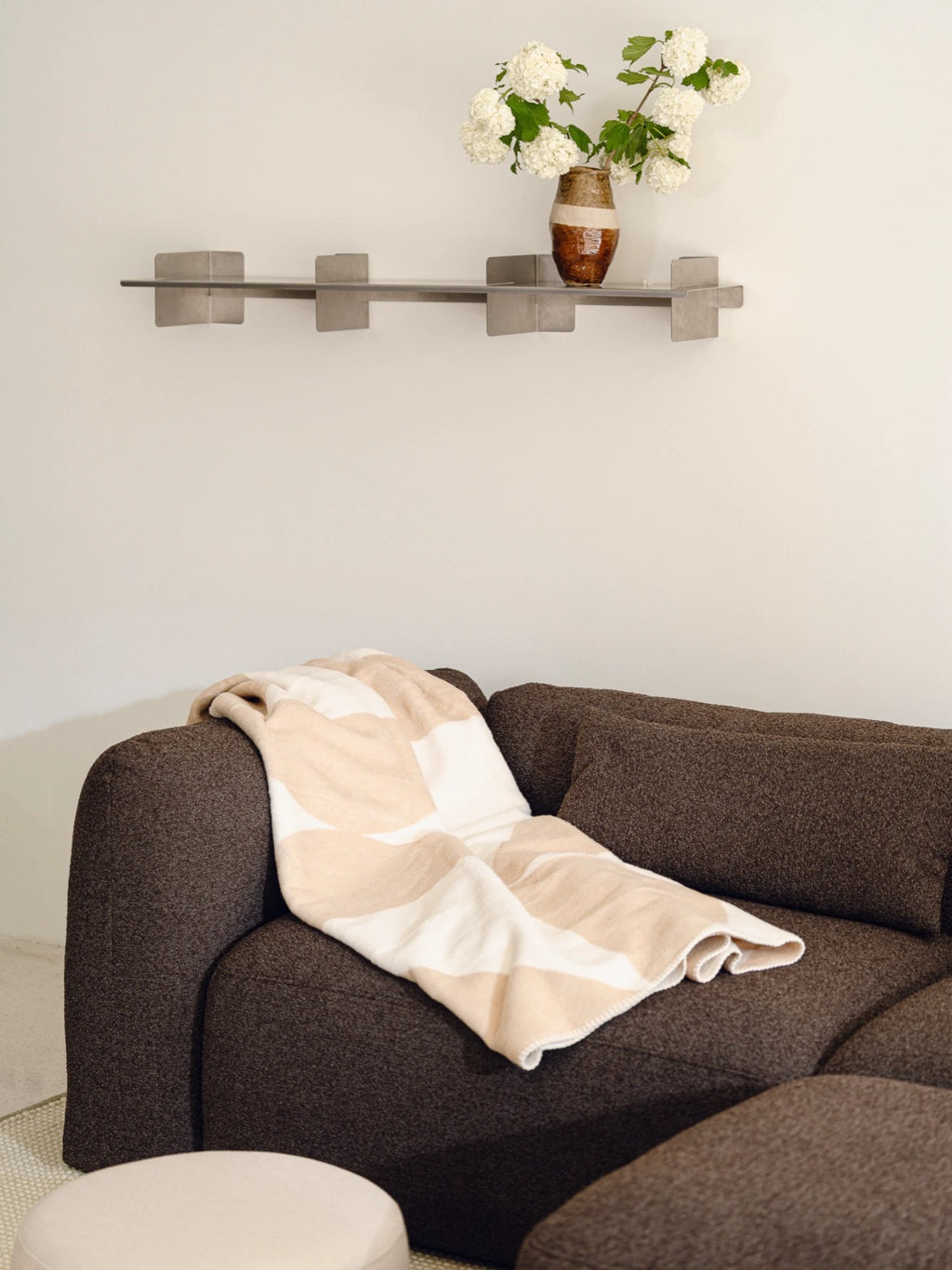 noo.ma Yaro Sofa, a contemporary modular sofa featuring a deep charcoal brown textured woven fabric upholstery, with a gently curved, organic silhouette and plush, deep seating. This versatile minimalist sectional is ideal for modern living rooms, offering flexible comfort and organic modern design.