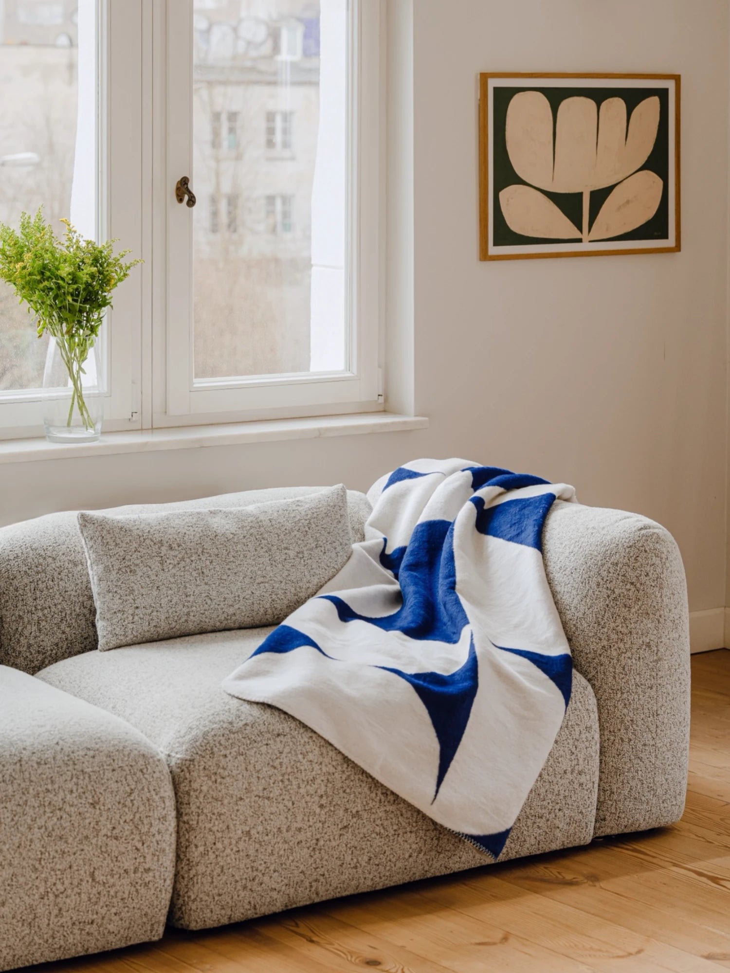 noo.ma Yaro Sofa, a contemporary modular sofa upholstered in a soft, textured light grey bouclé fabric with a subtle flecked appearance, featuring a low profile, gently curved organic silhouette, and deep, plush seating. Its rounded edges and modern minimalist design make it an ideal centerpiece for Scandinavian or organic modern living rooms.