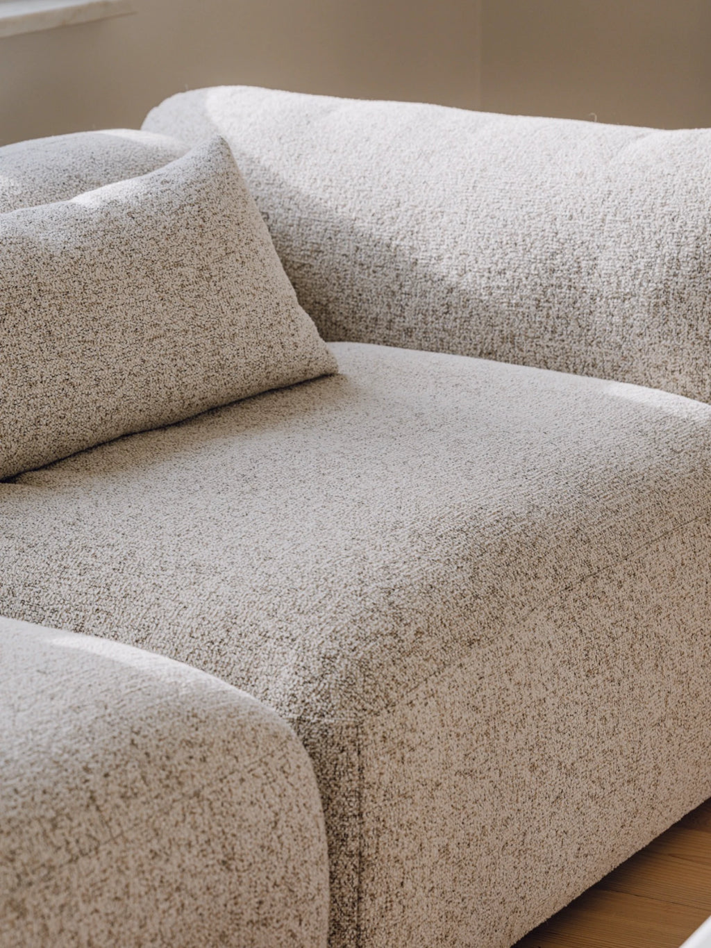 noo.ma Yaro Sofa, a luxurious organic modern modular sofa upholstered in a soft, textured cream bouclé fabric with subtle speckled flecks of tan and off-white. This deep-seating contemporary sectional features plush, inviting cushions and a low-profile design with gently rounded edges. Perfect as a comfortable living room sofa for minimalist, Scandinavian, or Japandi-inspired interiors.