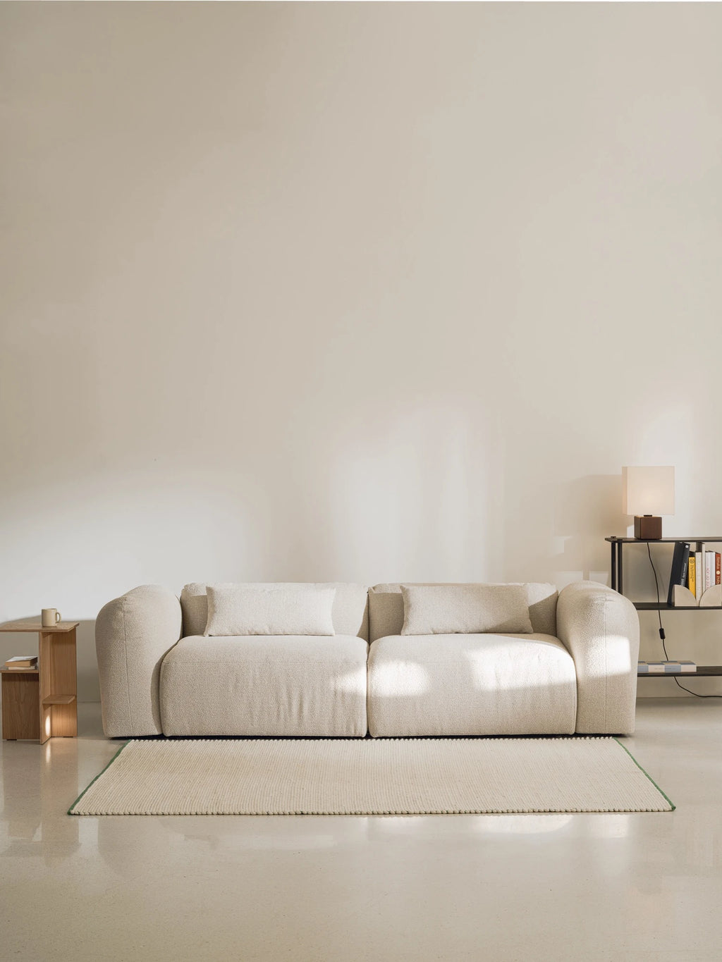 noo.ma Yaro Sofa, a plush cream bouclé sofa upholstered in a soft, textured off-white fabric, featuring a gently curved organic silhouette with inviting rounded armrests and deep seating.