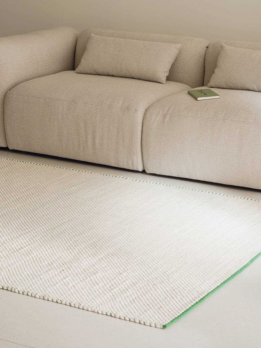 noo.ma Yaro Sofa, a low-profile modular sofa upholstered in a light beige textured bouclé fabric with plush deep seating and soft, organic curves. Its contemporary minimalist design and neutral tone make it an ideal choice for modern living rooms, cozy apartment spaces, or Scandinavian-inspired interiors.