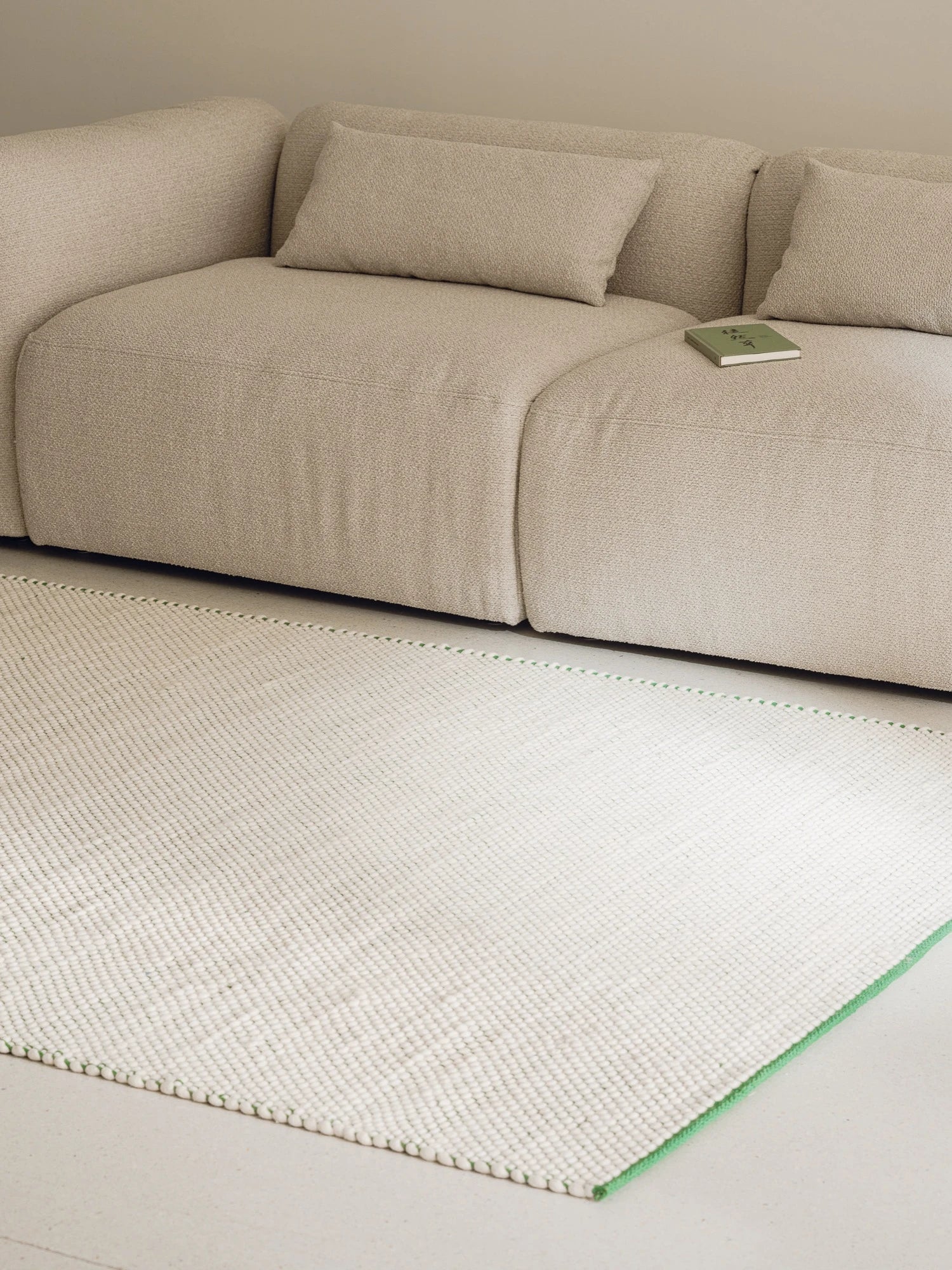 noo.ma Yaro Sofa, a low-profile modular sofa upholstered in a light beige textured bouclé fabric with plush deep seating and soft, organic curves. Its contemporary minimalist design and neutral tone make it an ideal choice for modern living rooms, cozy apartment spaces, or Scandinavian-inspired interiors.