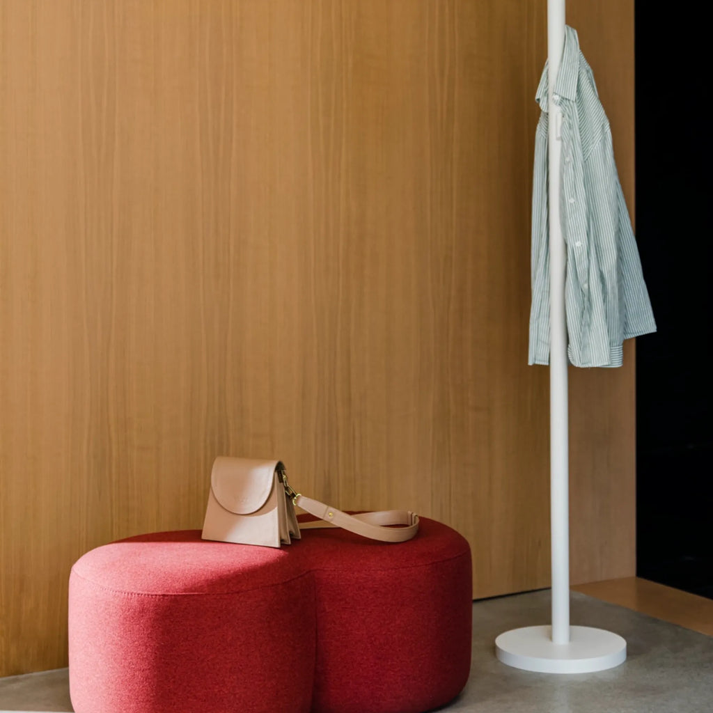 noo.ma Yuko Coat Rack, a sleek white minimalist coat rack featuring a tall, slender cylindrical pole and a sturdy round base, crafted from durable matte white metal. Its simple, modern design includes integrated pegs along the pole for hanging coats and accessories, blending seamlessly into contemporary spaces. Ideal for Scandinavian entryways, modern hallways, or minimalist bedrooms.