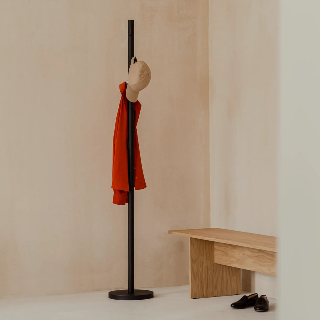 noo.ma Yuko Coat Rack, a sleek modern minimalist coat rack crafted from matte black metal, featuring a slender cylindrical pole with a stable round base and subtle integrated hooks for a clean, sculptural silhouette. This contemporary freestanding coat stand is perfect for Scandinavian entryways, Japandi-inspired mudrooms, or any modern minimalist home seeking functional elegance.