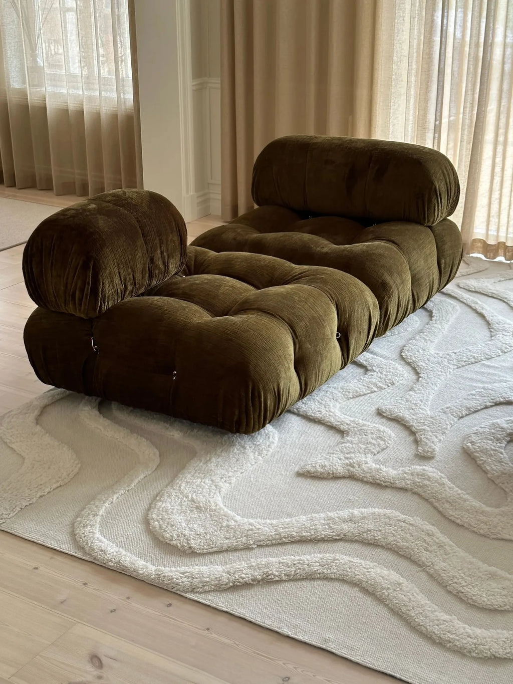 Tinted Objects Norlander Wool Rug, a luxurious cream-colored area rug with a stylish, raised wavy pattern in plush loop pile. This elegant, durable rug provides a soft, inviting texture to complement modern or minimalist living spaces.