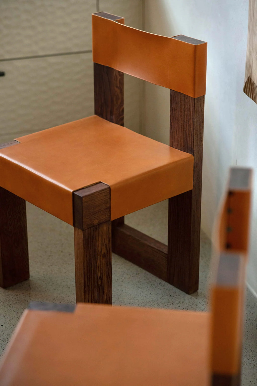 NG DESIGN Object 118 Chair, showcasing its rich brown-red wooden frame with visible grain details and a premium saddle tan leather seat and backrest, displayed in a well-lit interior. A beautiful, handcrafted piece for modern living spaces.
