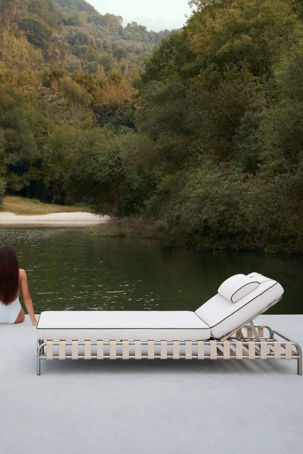 Gandia Blasco Onsen Chaise Lounge, a modern outdoor sunbed featuring a polished stainless steel frame and elegant natural leather straps supporting plush white upholstered cushions with sophisticated black piping. This contemporary chaise lounge offers an adjustable backrest for ultimate comfort and sleek minimalist design. Ideal for luxury pool decks, resort patios, or a modern garden retreat.