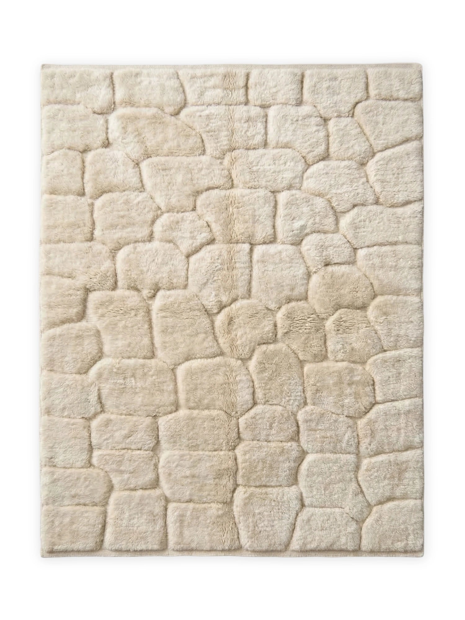 TCL Studios Cobble Wool Rug, a cream-colored hand-tufted wool rug featuring an organic, irregular cobblestone pattern with a high-pile plush texture in natural ivory tones. This cozy and soft area rug adds rustic modern charm and warmth to any space. Perfect for organic modern living rooms, minimalist bedrooms, or a welcoming entryway.