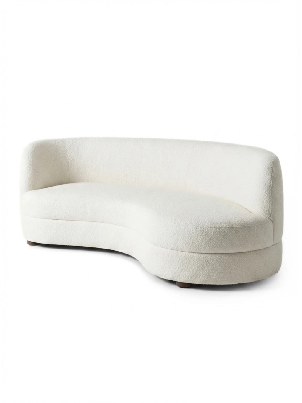 Tinted Objects Delon Sofa, an elegant curved modern sofa upholstered in luxurious cream bouclé fabric with a textured finish and subtle dark wood feet. This stylish, contemporary piece is perfect for a sophisticated living room or lounge area, ideal for those seeking unique, high-end furniture.