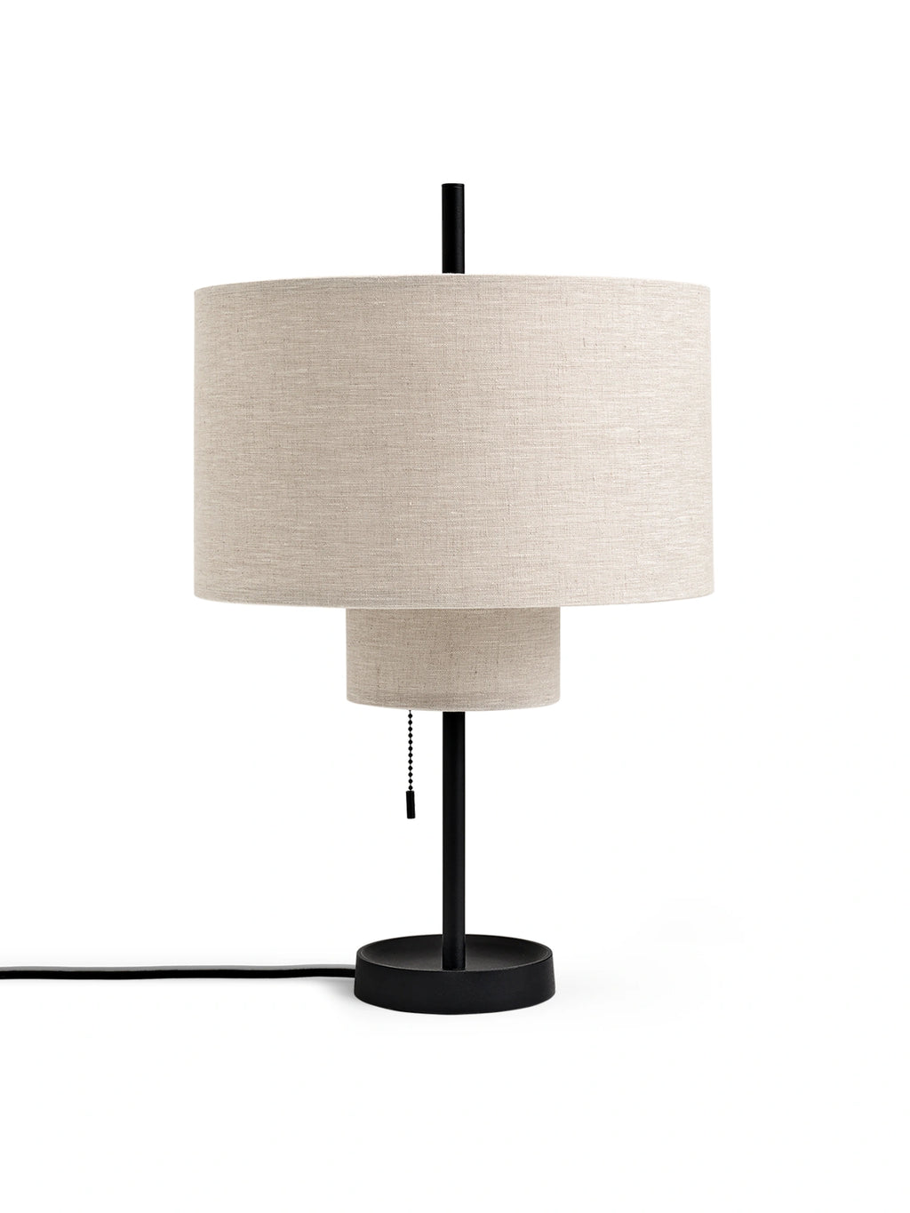 New Works Margin Table Lamp featuring stacked light beige linen fabric shades with a visible texture, a black metal stem, base, and pull-chain. This premium modern, minimalist lighting piece is perfect for a stylish contemporary interior.
