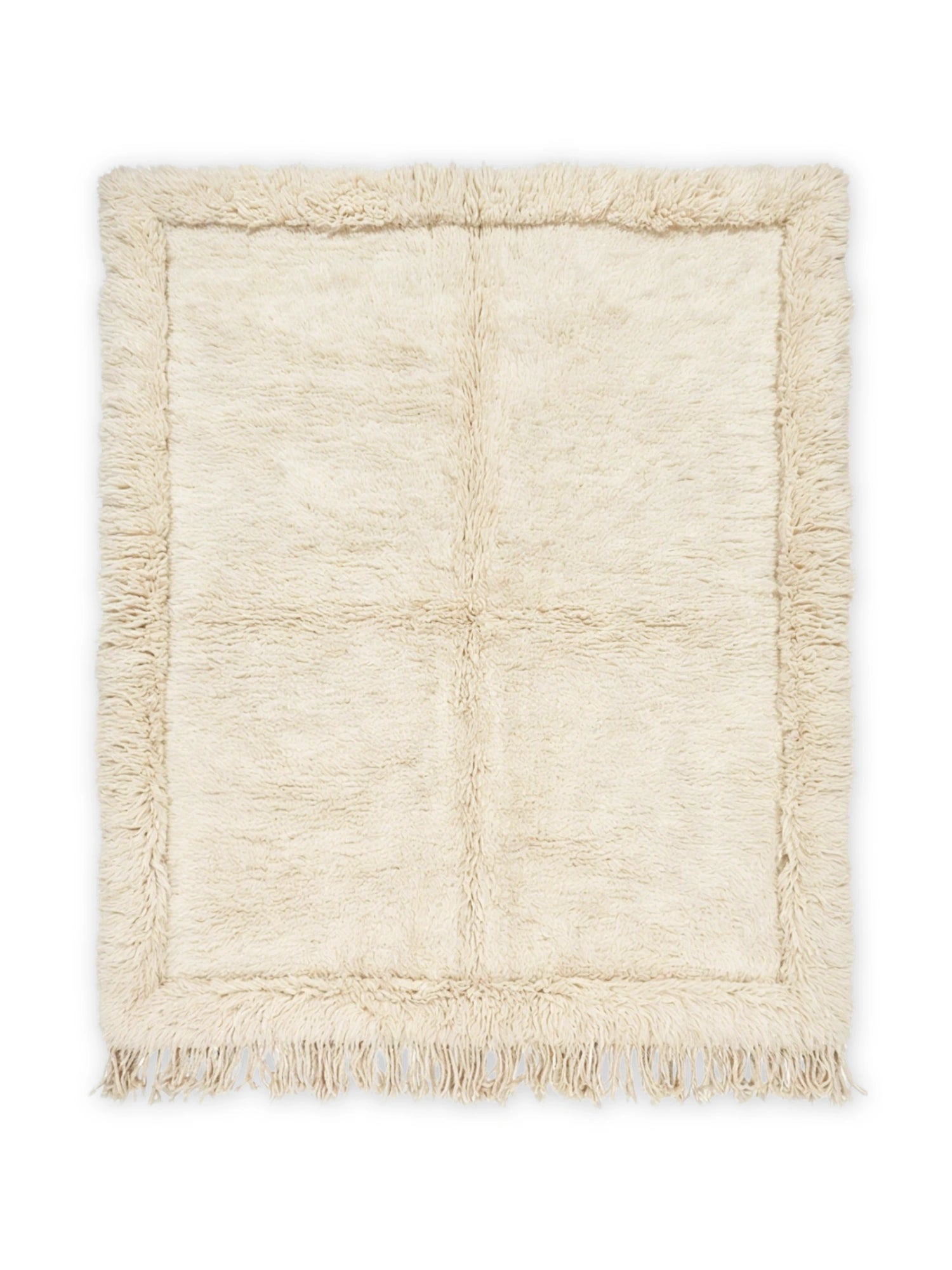 TCL Studios Summit Shaggy Rug, a luxurious hand-knotted natural wool area rug in a soft cream color, featuring a plush, high-pile shaggy texture and a distinct rectangular border with delicate fringe detailing. This cozy, organic modern rug offers warmth and softness, perfect for creating an inviting atmosphere in Scandinavian living rooms, boho bedrooms, or minimalist spaces.