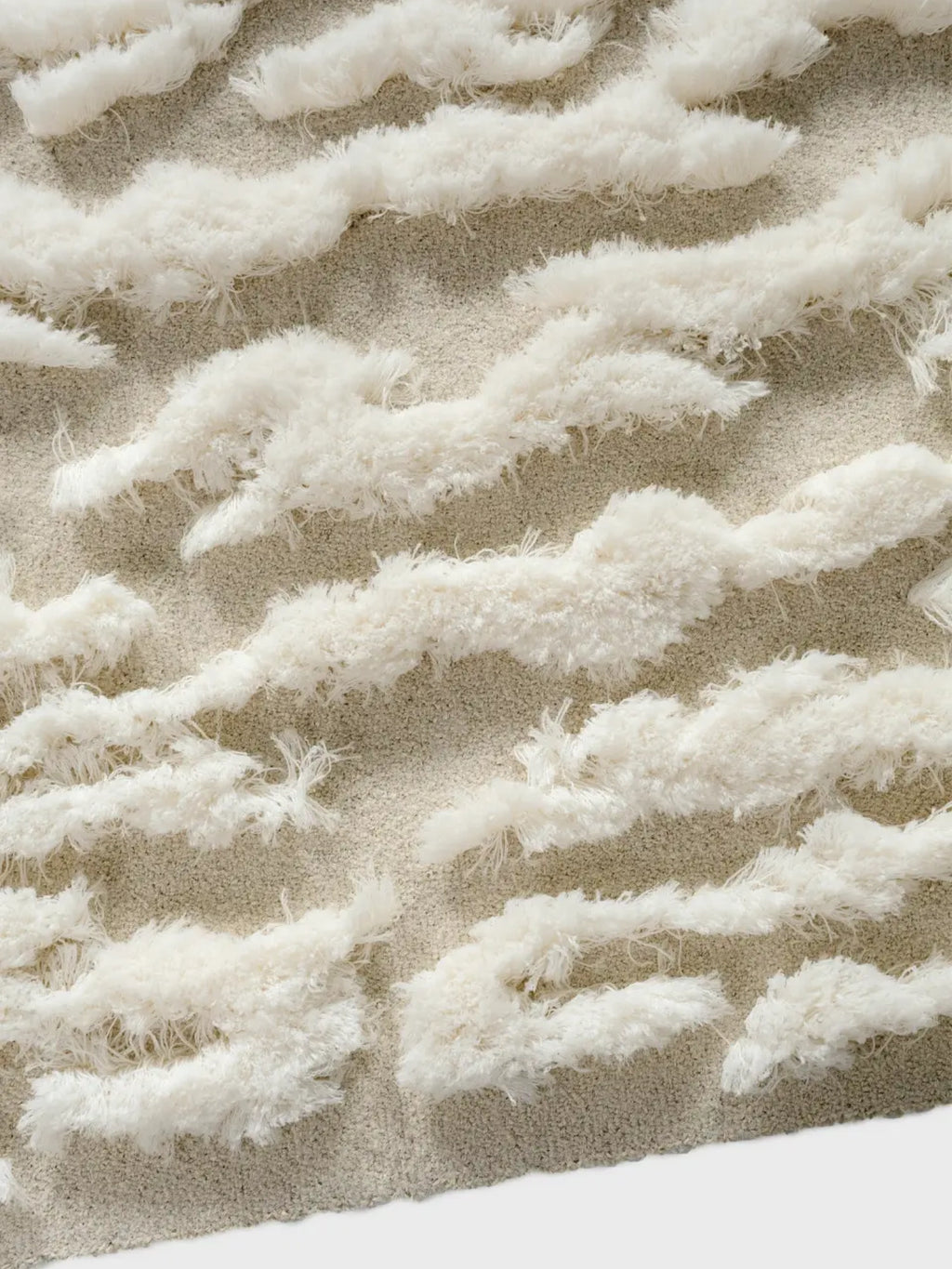 alp_ Plage Sauvage Rug, a cream and light beige textured area rug featuring a plush, high-pile shaggy abstract wave pattern against a soft, low-pile base. This organic modern rug creates a cozy, inviting atmosphere, perfect for contemporary living rooms, bedrooms, or a boho nursery.