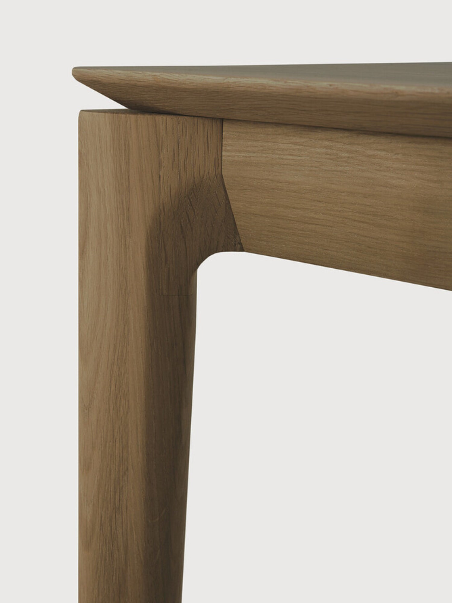 Ethnicraft Bok Bench, a modern minimalist solid oak bench crafted from natural light oak wood with a smooth finish and visible grain. It features distinctive tapered legs and an organic, seamlessly carved joinery where the legs meet the rectangular bench top. Ideal as a Scandinavian dining bench, stylish entryway seating, or a versatile accent piece for contemporary living rooms.