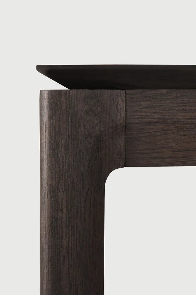 Ethnicraft Bok Extendable Dining Table, a striking modern minimalist dining table crafted from solid dark oak wood, featuring a rich, deep brown finish that highlights its natural wood grain.