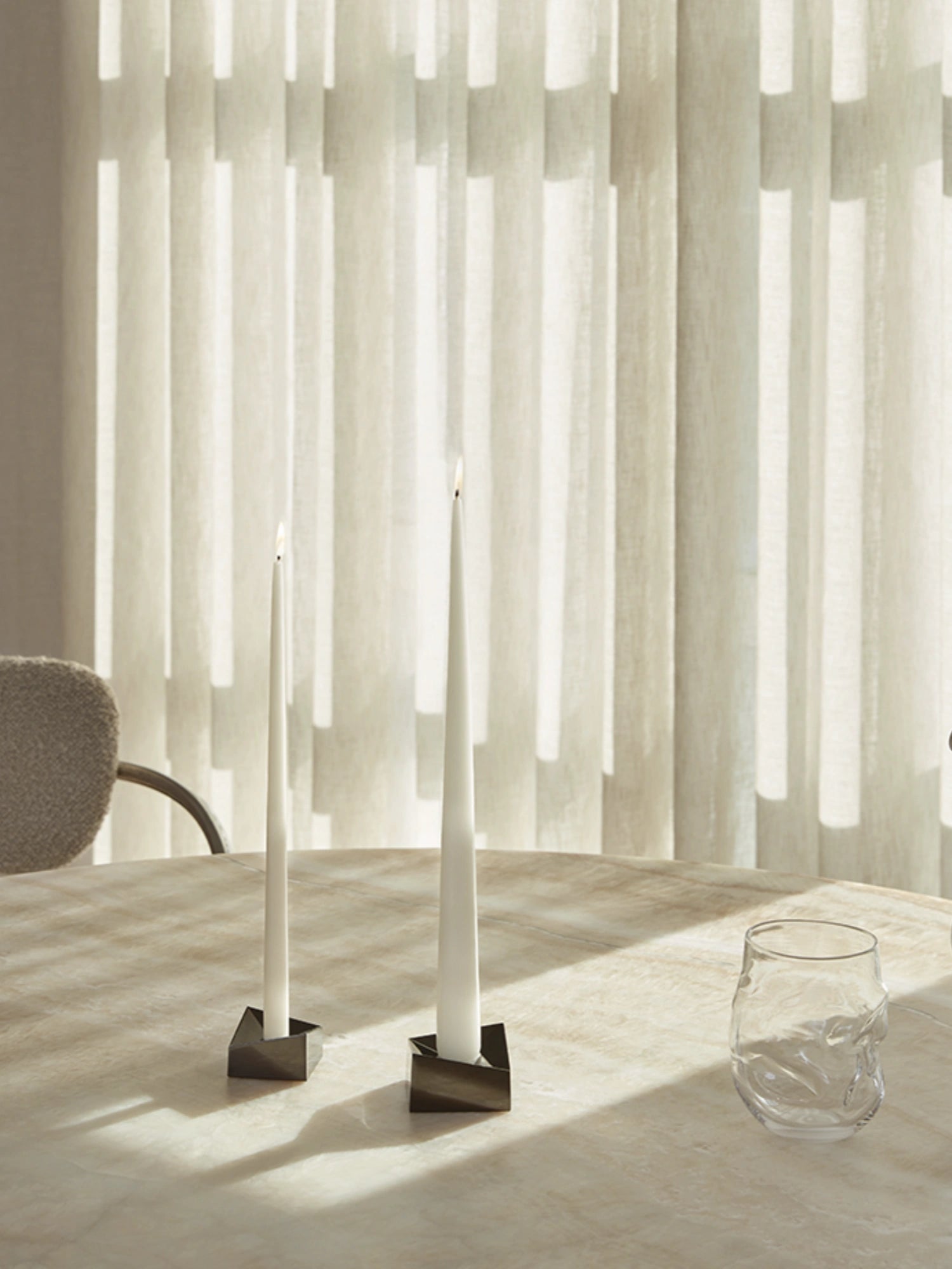 Stoff Nagel Reflect Candle Holder, a modern minimalist taper candle holder crafted from dark polished metal with a distinctive geometric, faceted design, creating a sculptural effect. Ideal for contemporary dining table centerpieces, elegant mantel decor, or minimalist shelf styling in design-led homes.