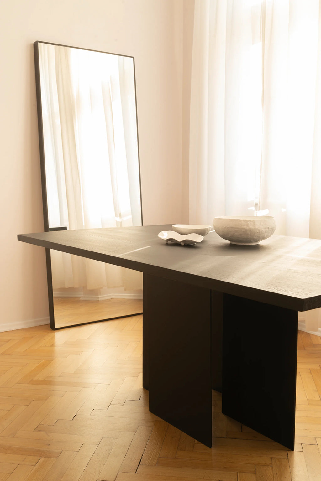 NG DESIGN Object 056 Dining Table, featuring a rectangular matte black wood top and structural panel legs, styled with decorative white bowls, offering a luxury dining experience.
