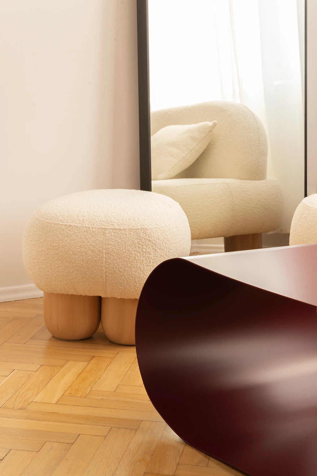 NG DESIGN Object 049 Pouf, an off-white bouclé upholstered, mushroom-shaped pouf with light wood block feet, on a wooden herringbone floor. This luxury furniture piece is ideal for modern interiors.