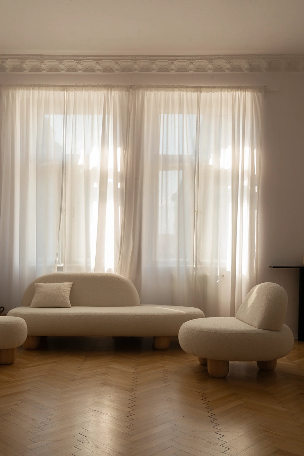 NG DESIGN Object 047 Sofa, a luxurious ivory boucle curved low-back sofa and matching armchair with round wooden legs, styled in a minimalist living room. Creates a stylish, cozy lounge space.