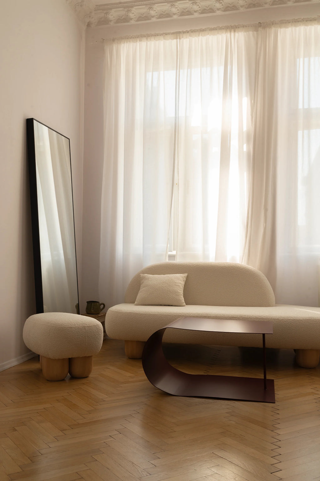 NG DESIGN Object 047 Sofa in a living room, a beautiful cream bouclé fabric chaise lounge sofa with rounded back and cushions, on light wooden sculptural legs. A premium, aesthetic furniture piece. Ideal for modern interior design.