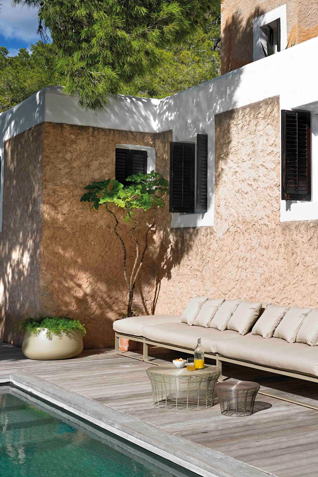 Gandia Blasco Sahara Outdoor Planter 3, a modern minimalist outdoor planter in a soft greige hue, featuring a wide, low, and organically rounded pebble shape with a smooth matte finish. Crafted from durable rotation-molded polyethylene, this large garden pot is perfect for contemporary patio decor or Mediterranean-inspired outdoor living spaces.