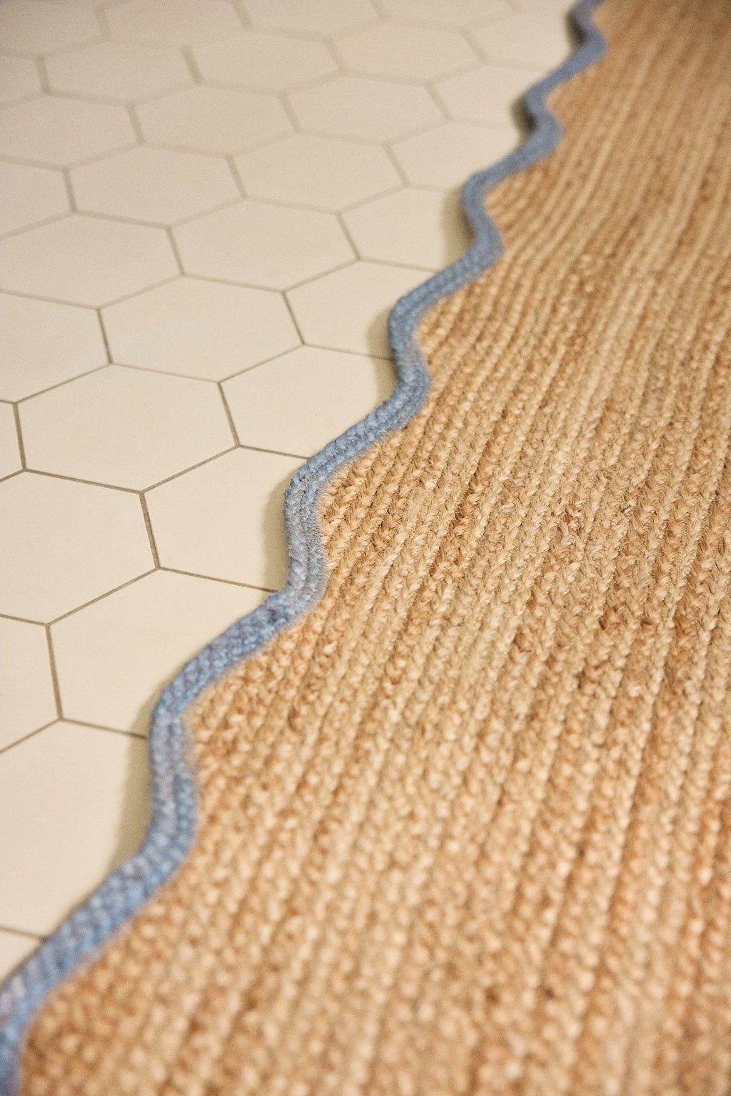 Jute rug with blue border on a tiled floor