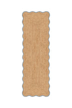 Rectangular jute rug with scalloped edge on a white background
