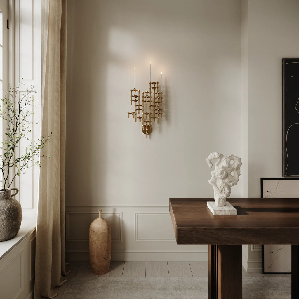 Stoff Nagel Wall Hanger Candle Holder - Solid Brass - Configuration 2, a sculptural mid-century modern wall-mounted candle holder crafted from warm gold-toned solid brass, featuring a modular design of interlocking spheres and rods that create a cascading, geometric form. This brutalist-inspired brass wall art is perfect for contemporary living rooms, dining rooms, or entryways seeking a distinctive focal point.