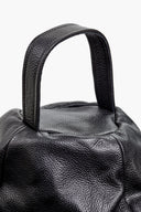 Close-up of a black leather handbag handle on a white background