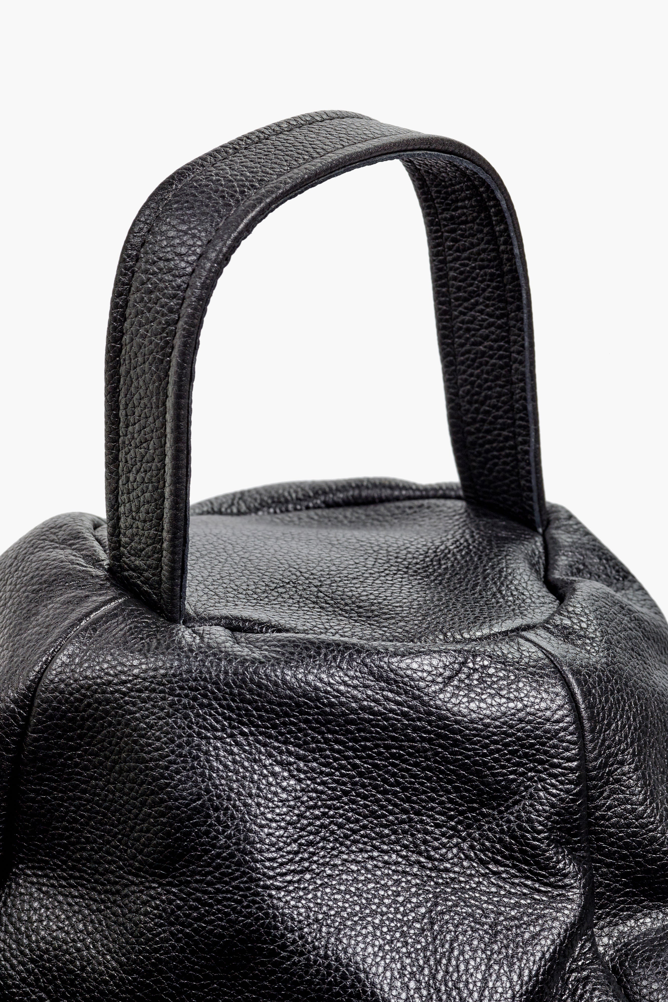 Close-up of a black leather handbag handle on a white background