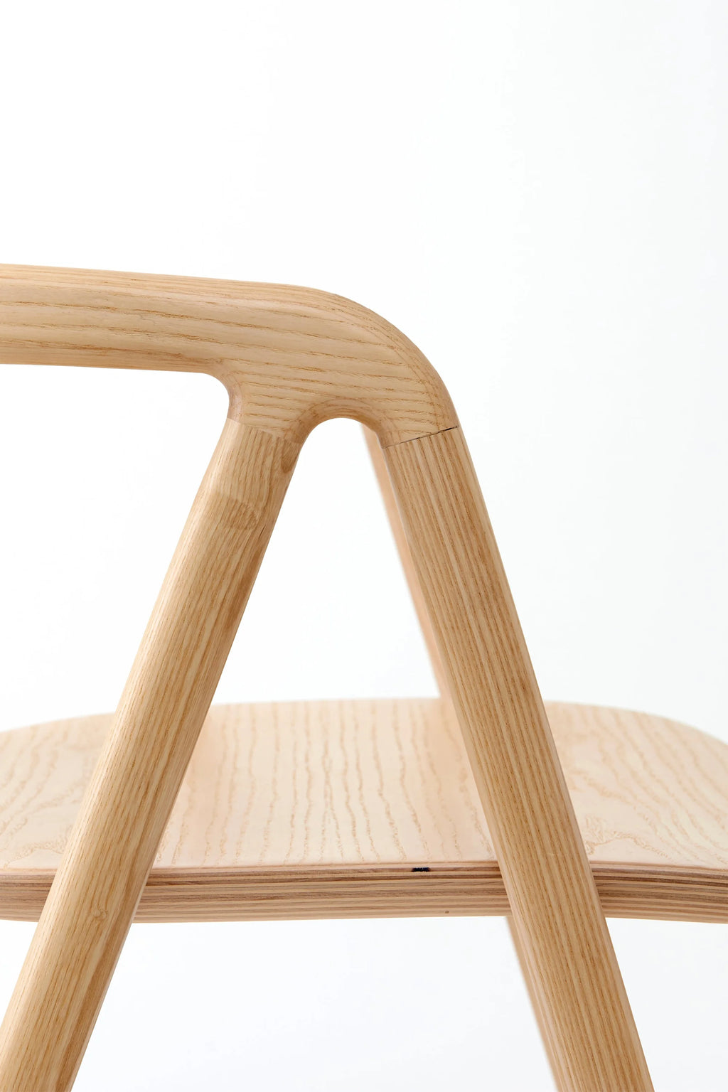 Made by Choice Laakso Dining Chair, a close-up of the elegant curved backrest and sturdy wooden frame, highlighting the seamless joinery and natural wood texture of this premium dining chair, on a white background.