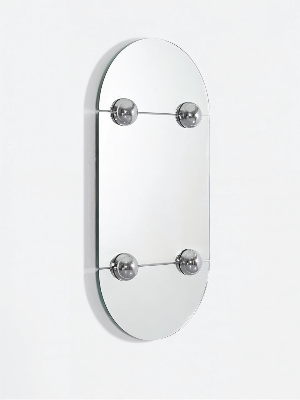 Moustache Sphera Oblong Mirror, a close-up, angled view of the contemporary mirror, highlighting its unique design with two rectangular mirror sections held by four prominent, polished chrome spheres, set against a clean white background, reflecting light beautifully.