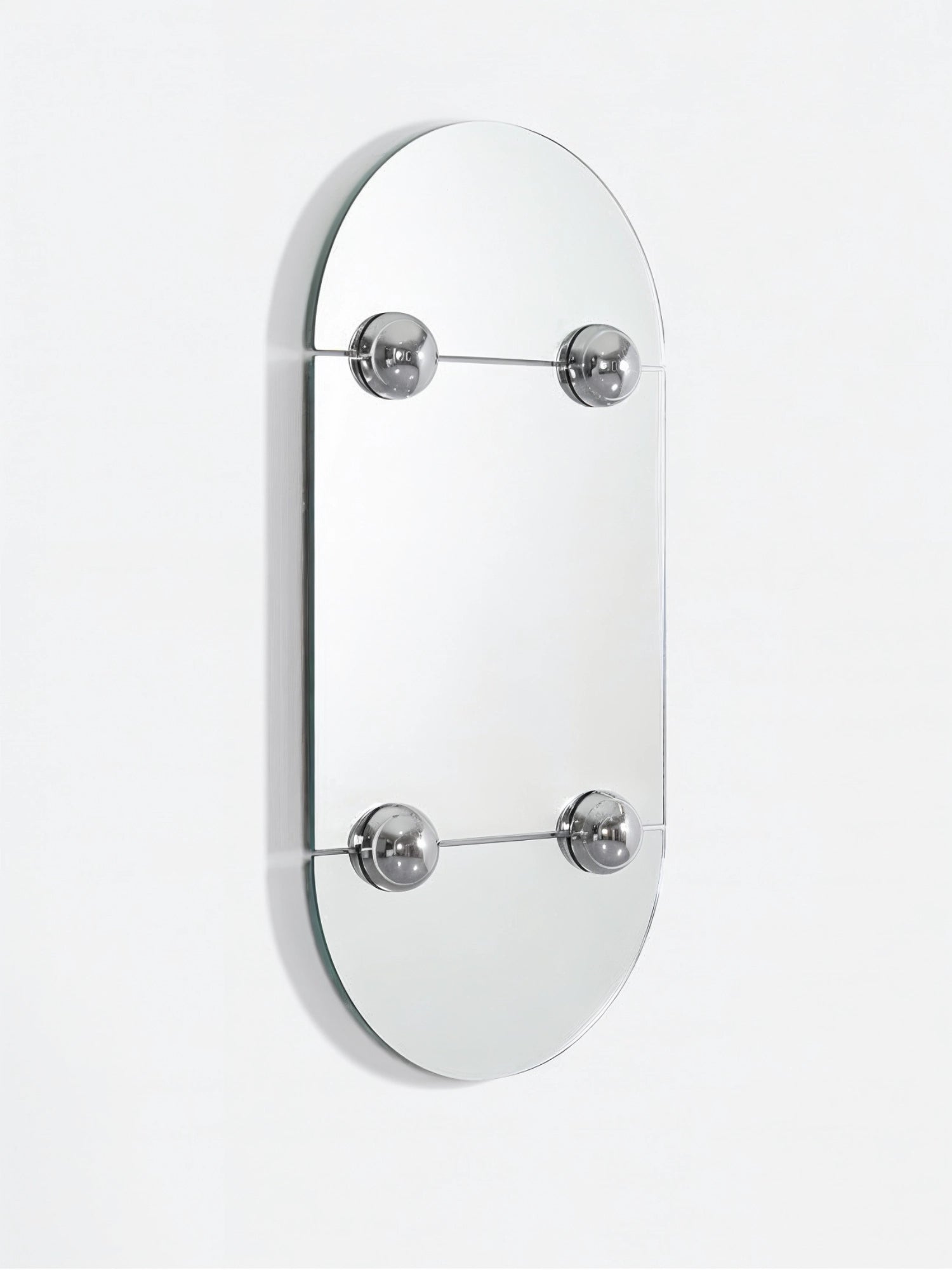 Moustache Sphera Oblong Mirror, a close-up, angled view of the contemporary mirror, highlighting its unique design with two rectangular mirror sections held by four prominent, polished chrome spheres, set against a clean white background, reflecting light beautifully.