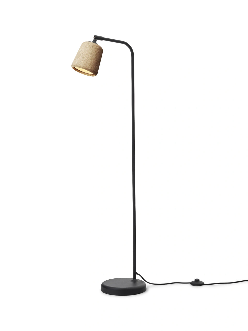 New Works Material Floor Lamp, a sleek modern minimalist floor lamp featuring a matte black metal frame with a gently curved arm and a cylindrical natural cork shade. The textured cork provides a warm, organic contrast to the clean lines of the black metal stand and round base. Ideal as a Scandinavian reading lamp for living rooms, bedrooms, or contemporary home offices.
