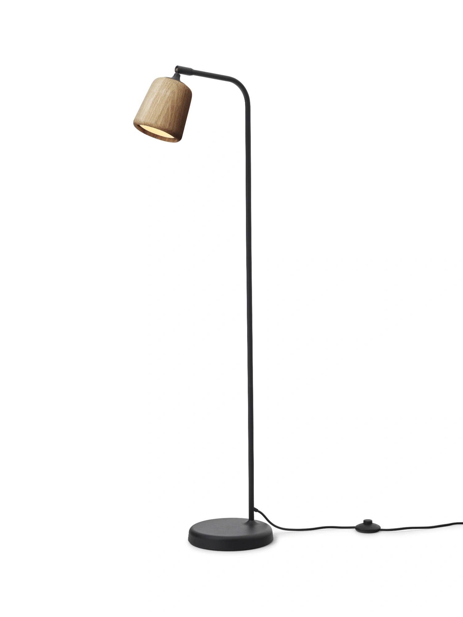 New Works Material Floor Lamp, a sleek modern minimalist floor lamp featuring a slim matte black metal stand with a gently curved arm and a natural light wood conical shade. The shade showcases a beautiful, visible wood grain, providing a warm contrast to the industrial chic black base. Perfect as a Scandinavian accent lamp for contemporary living rooms, minimalist bedrooms, or cozy reading nooks, offering focused illumination.