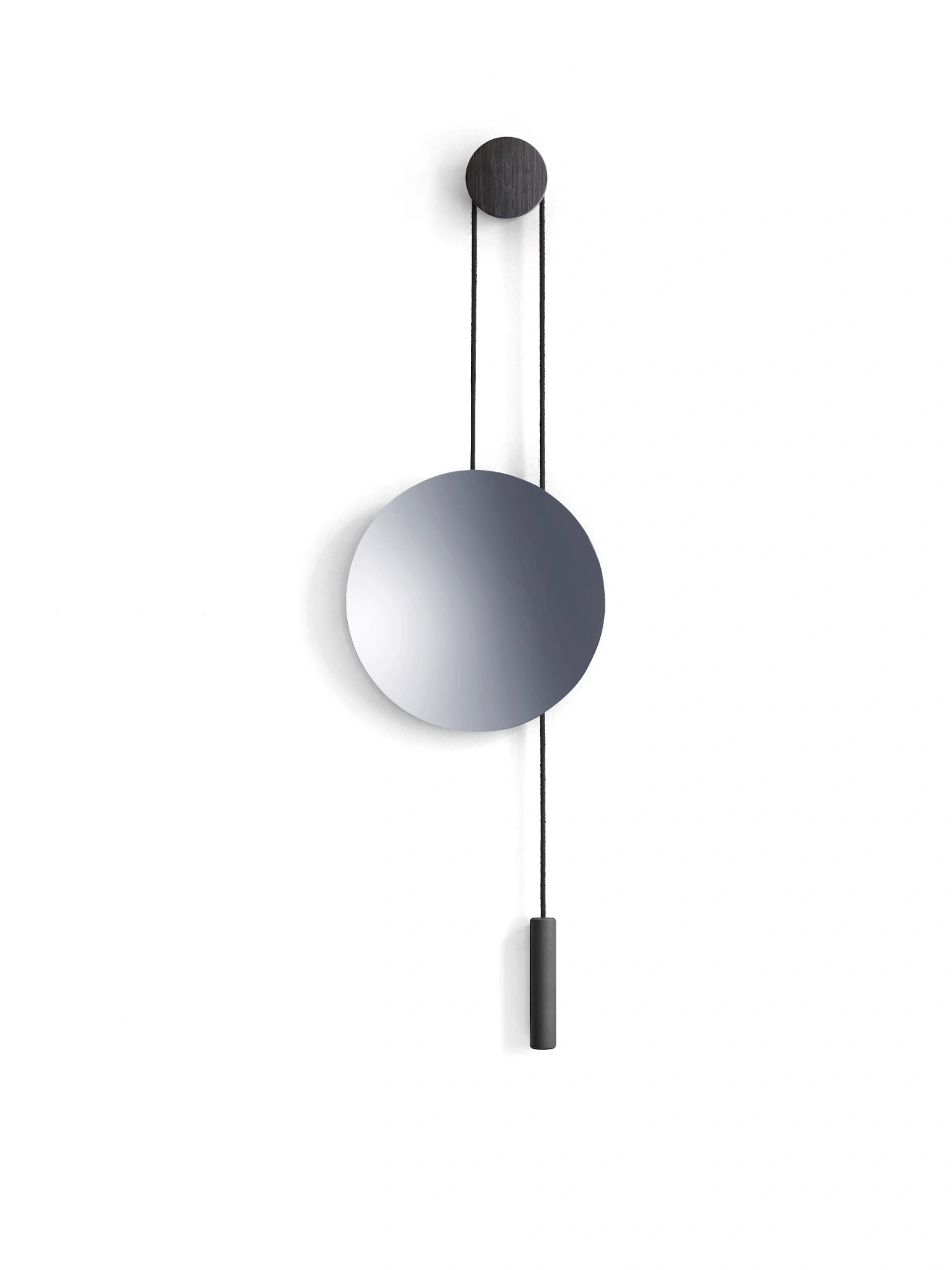 New Works Rise & Shine Wall Mirror, featuring a circular silver-tone glass mirror and a dark stained oak wall mount with black cord and weight, on white background. A luxury decorative accent for any modern interior.