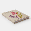  A close-up of The Seasonal Gardener book featuring vibrant plants and gardening tools