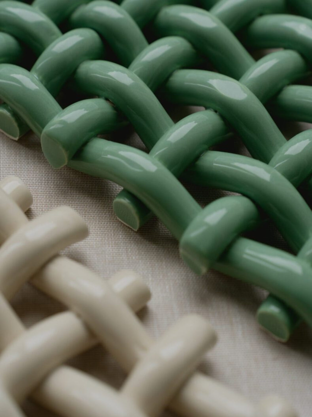 The Poster Club Interlace No. 02, a contemporary abstract art print showcasing a mesmerizing woven pattern of glossy, rounded ceramic-like forms in soft sage green and creamy off-white.