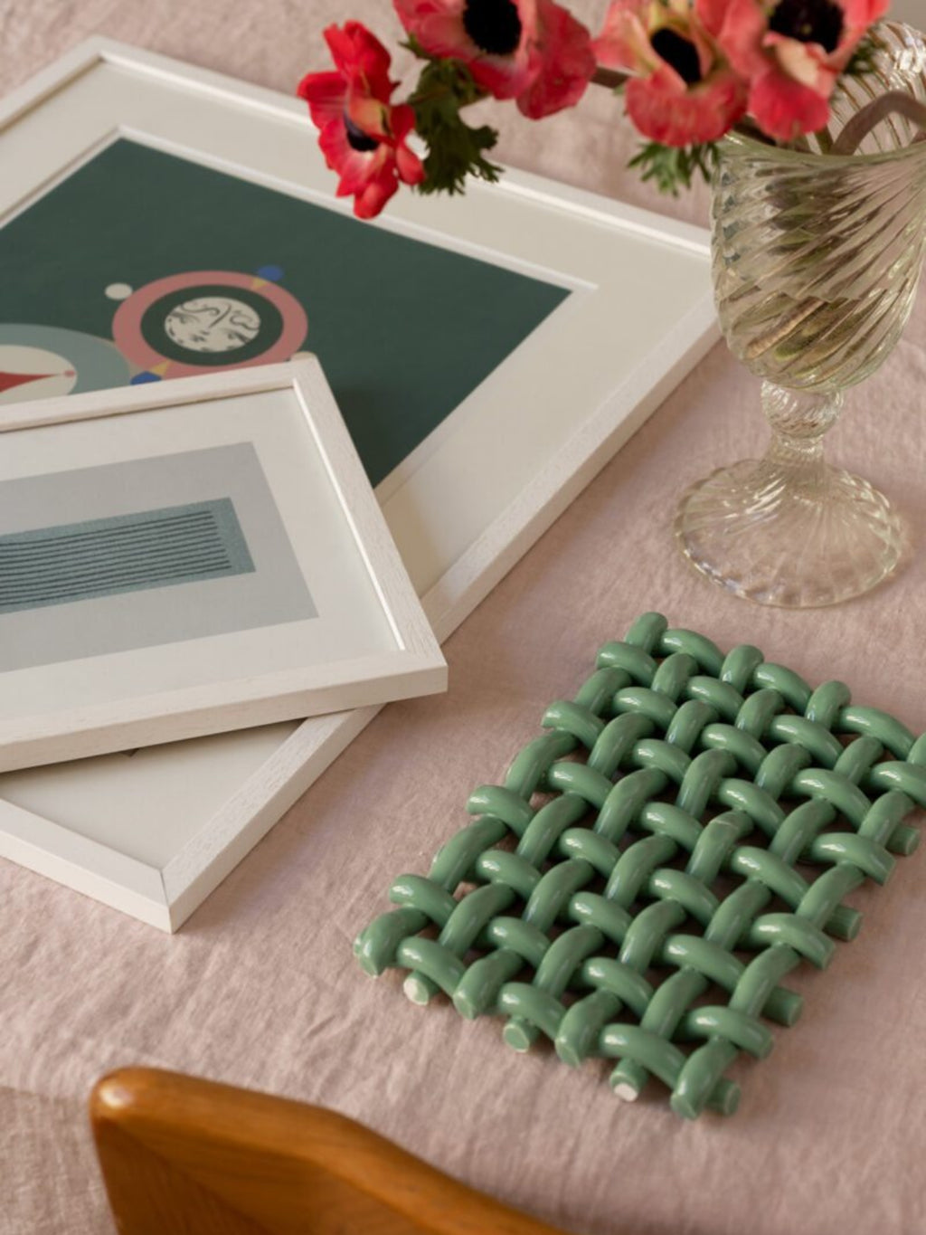 The Poster Club Interlace No. 02, a vibrant abstract art print featuring playful geometric shapes in pink, light blue, and yellow against a deep dark teal background, framed in a clean white.