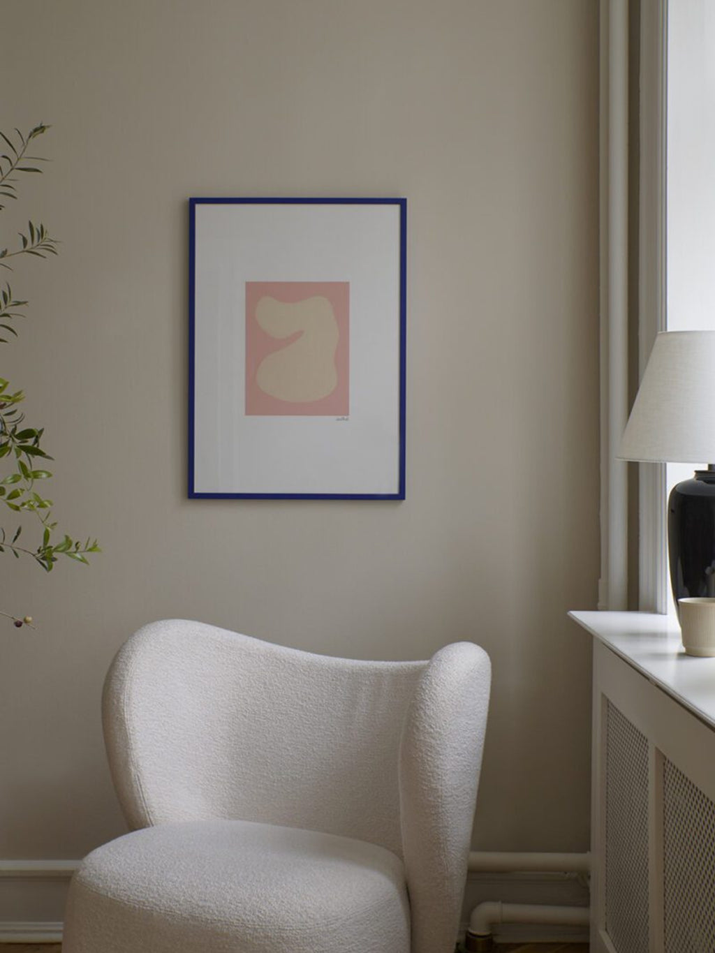 The Poster Club Shape Study 01, a minimalist abstract art print featuring a soft beige organic shape against a muted pink background, framed in a bold royal blue frame with a crisp white mat. Perfect as contemporary wall art for modern minimalist, organic modern, or Scandinavian-inspired living rooms and bedrooms.