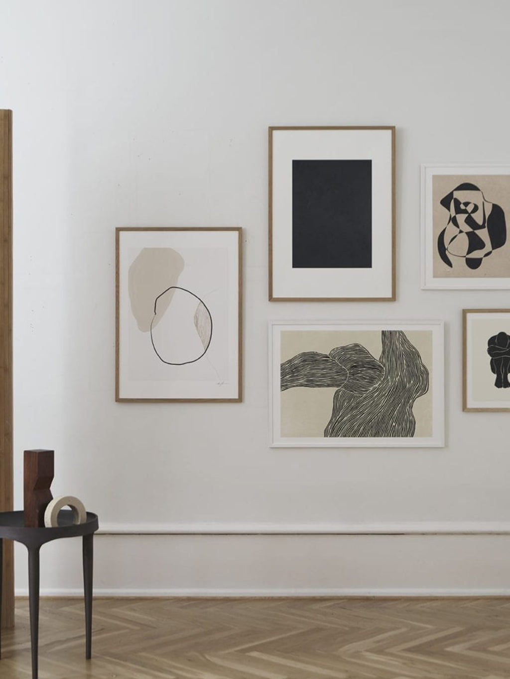 The Poster Club STATIC 02, an abstract art print featuring bold black organic shapes against a warm beige background, framed with a crisp white mat and a natural oak frame. This minimalist and contemporary poster is perfect for Scandinavian gallery walls, organic modern living rooms, or serene bedroom decor.