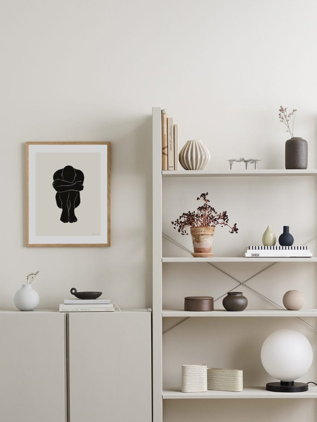 The Poster Club STATIC 02, a modern minimalist art print featuring a bold abstract black human figure in a crouched pose against a soft light beige background, framed in natural oak with a white mat. This contemporary figural wall art is perfect for adding a serene, thought-provoking touch to Scandinavian living rooms, minimalist bedrooms, or stylish gallery walls.
