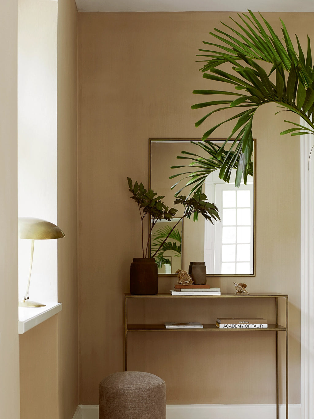 Tine K Metal Console Table, a modern minimalist console table crafted from brushed brass-finished metal with a sleek, open rectangular frame and two integrated shelves. Its warm gold tone and clean lines make it a versatile piece for contemporary entryway decor or as a stylish living room accent.