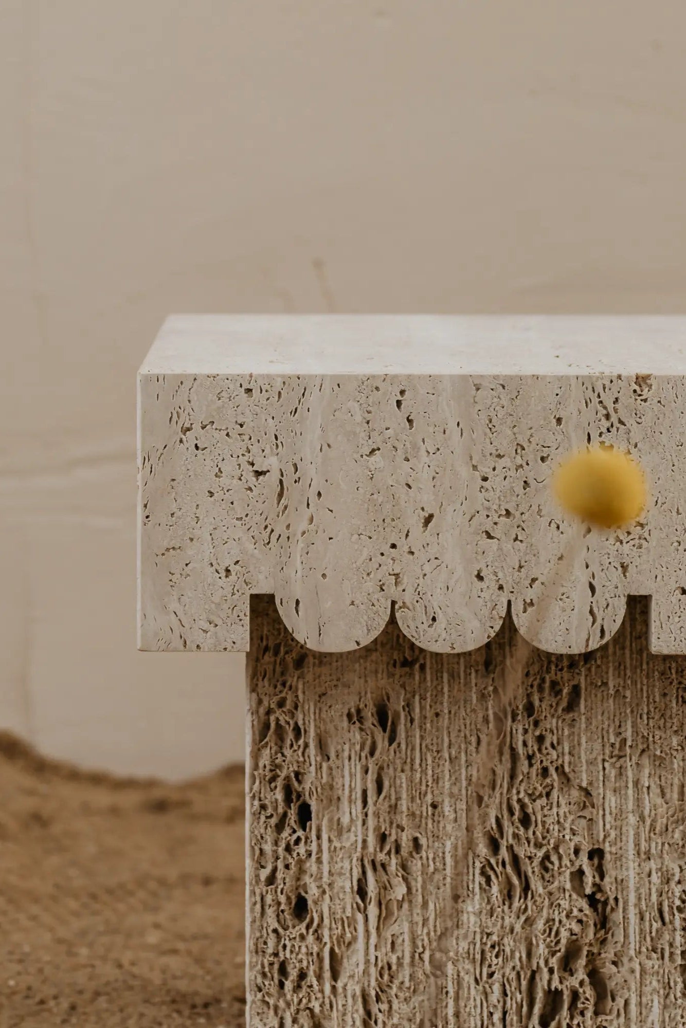 un'common Oro Side Table, a sculptural organic modern side table crafted from natural travertine stone in warm beige and cream tones.