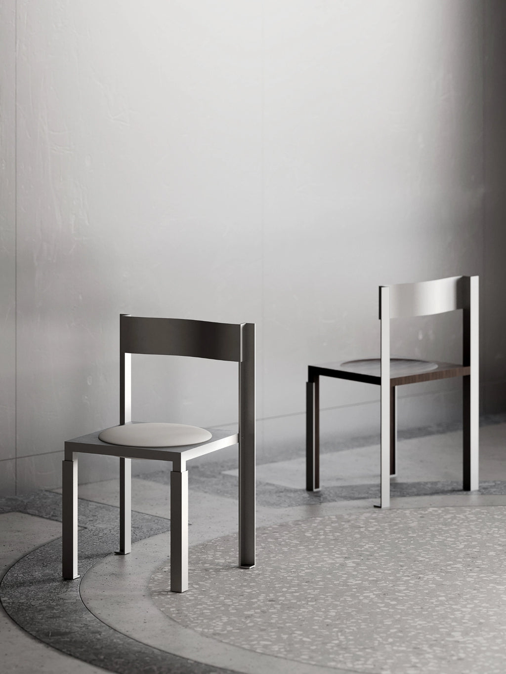 YET. Strut Chair, a modern minimalist dining chair crafted with a robust brushed metal frame in a sleek silver-grey finish. It features a bold, angular silhouette, a flat rectangular backrest, and a soft, round light cream upholstered seat cushion. A second chair in the background displays an alternative dark wood seat, offering a versatile option for contemporary dining rooms or industrial chic interiors.