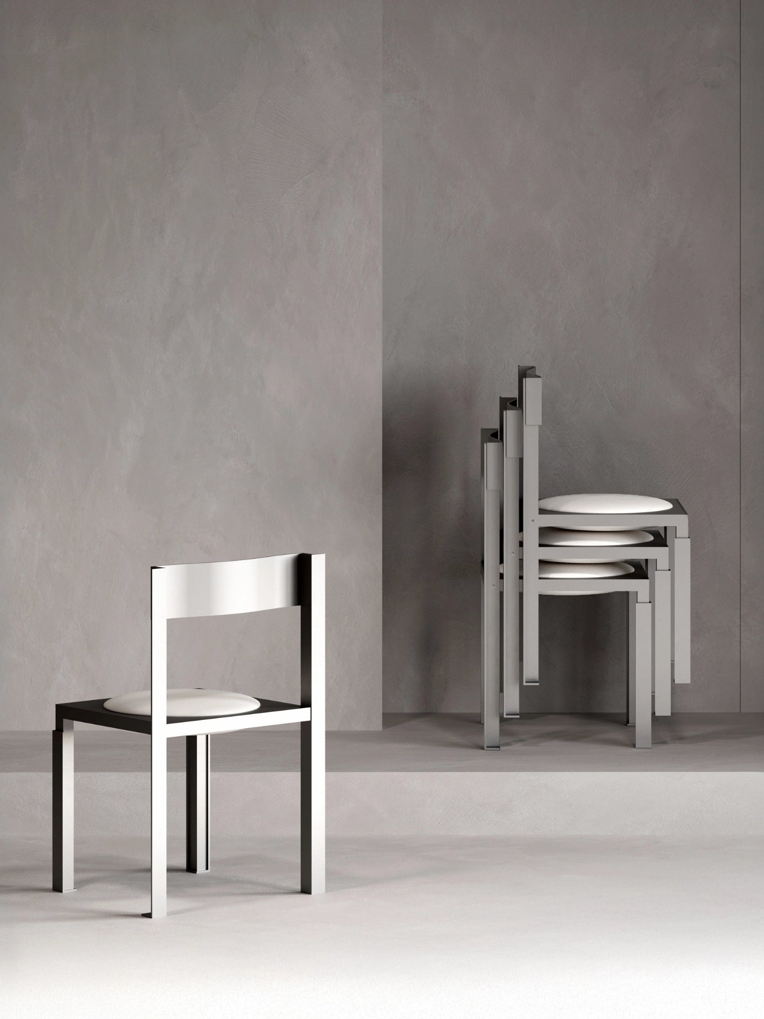 YET. Strut Chair, a bold brutalist dining chair featuring a striking geometric frame crafted from matte grey metal with visible structural elements and a contrasting black seat base. This industrial chic chair includes a comfortable round white upholstered cushion and boasts a convenient stackable design. Perfect for contemporary dining rooms or modern industrial interiors.
