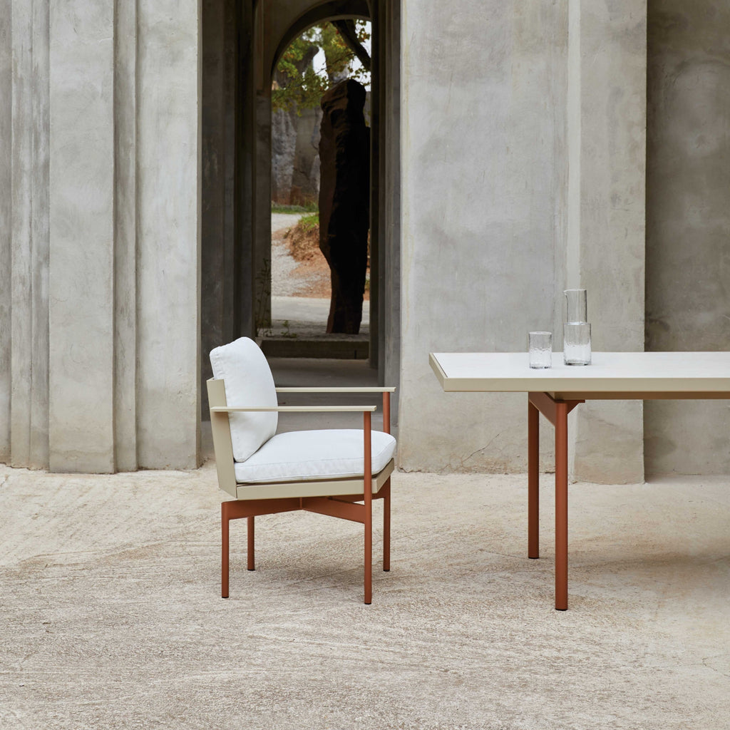 Gandia Blasco Onde Dining Table, a modern minimalist outdoor dining table with a sleek rectangular light beige tabletop and sturdy terracotta-colored powder-coated aluminum legs.